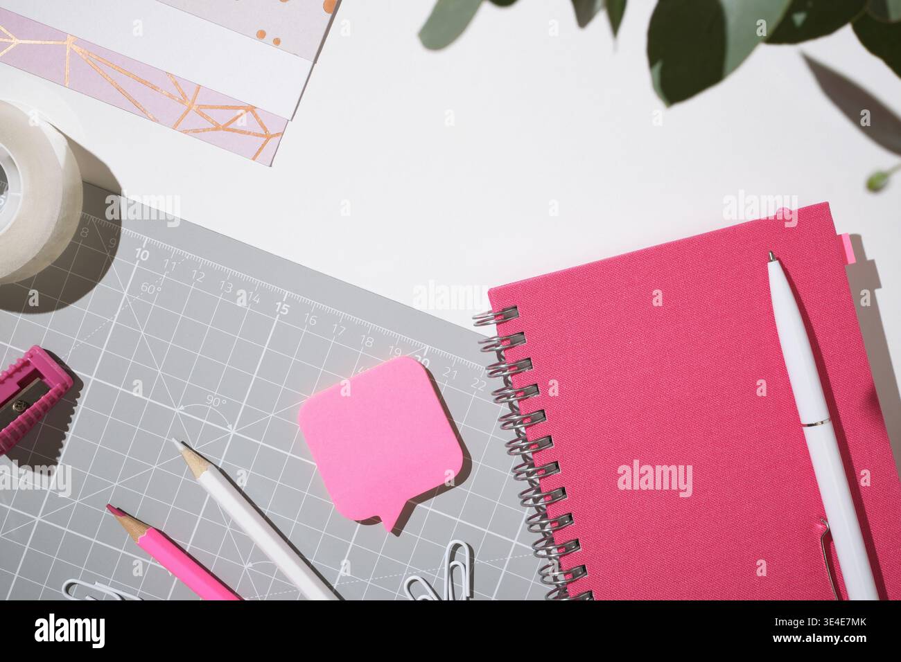 Pink workspace flat lay with notebook and clips for creative planning on white background. Copyspace. Stock Photo