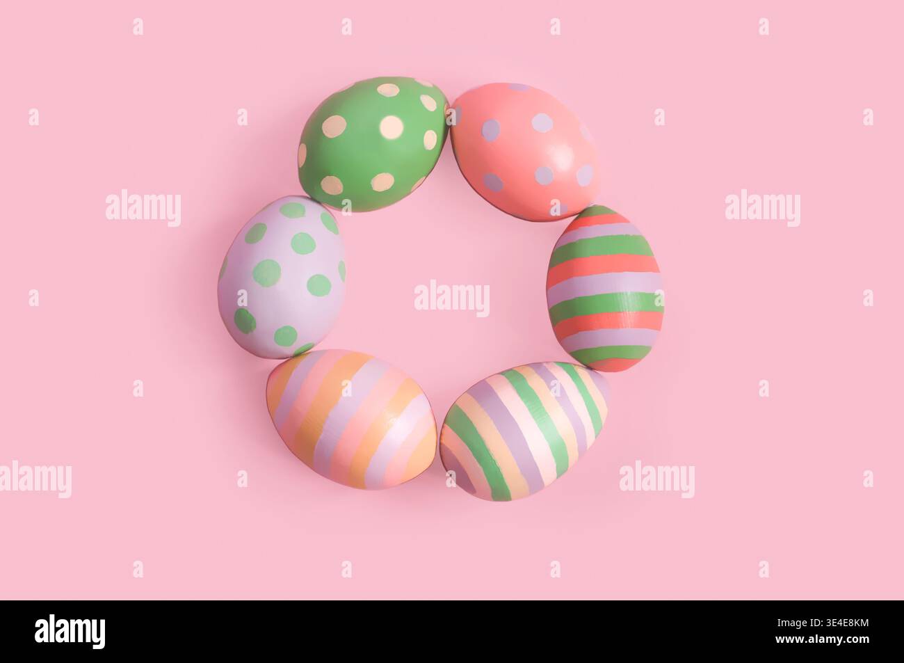 decorative painted Easter eggs lie in a ring on a pink background Stock Photo