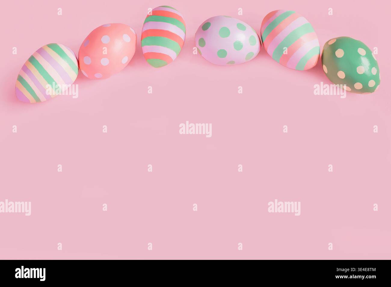 Easter multi-colored eggs on a pink background lie in a row Stock Photo