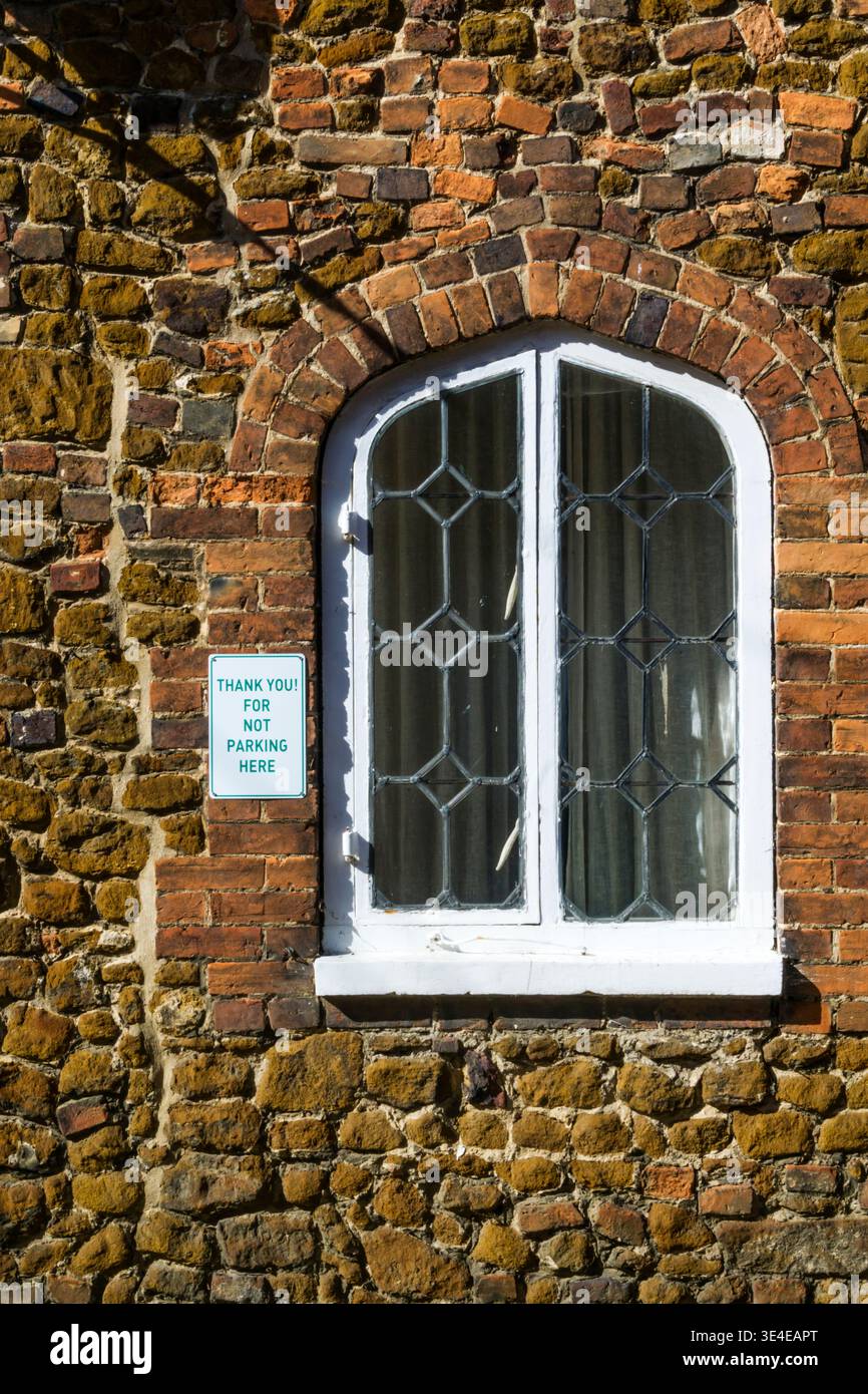 A Thank You for Not Parking Here sign on an old building. Stock Photo