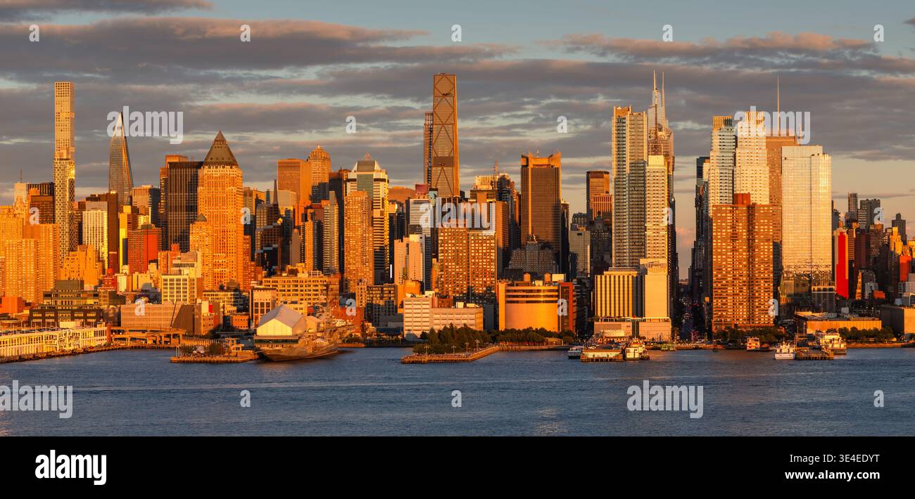 Golden hour view of Midtown Manhattan skyline along the Hudson River, New York City, USA. Skyscrapers and urban cityscape in warm sunset light Stock Photo
