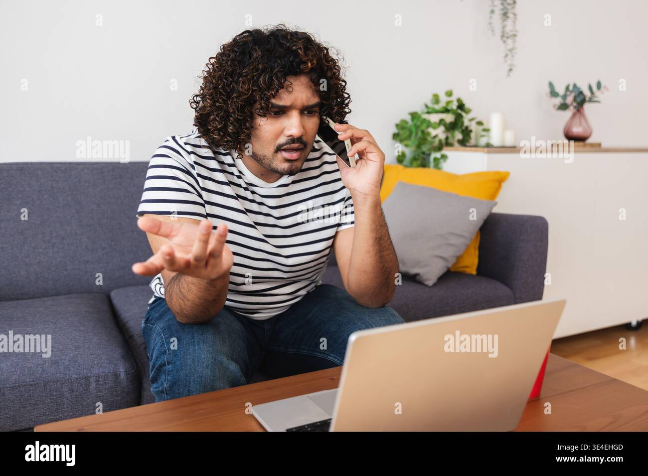Young Indian man focused while working on laptop Stock Photo