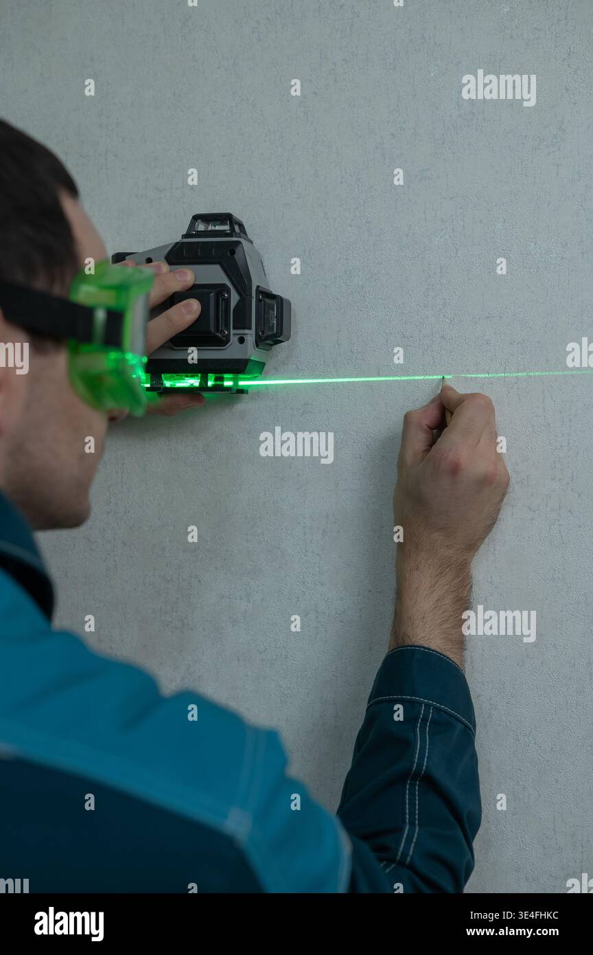 A man measures distance with a laser level.  Stock Photo