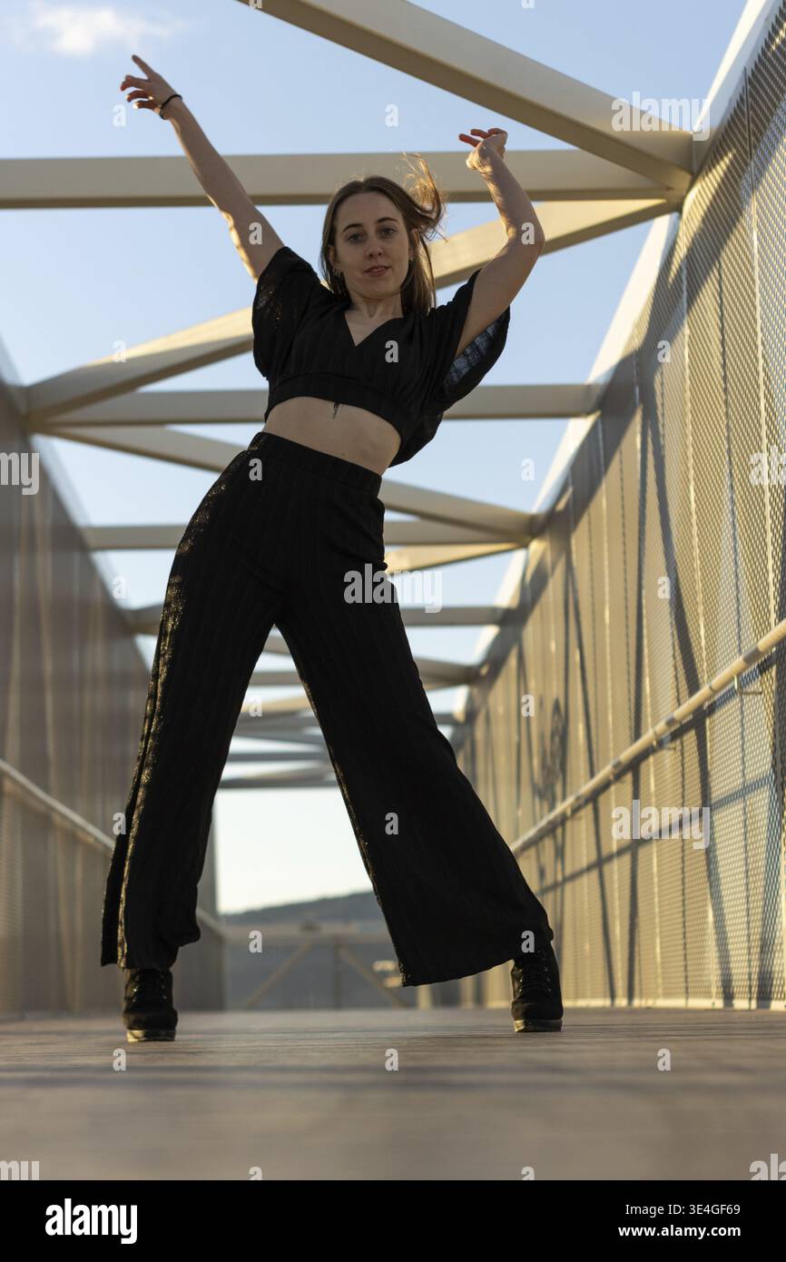 Dancer practicing a modern choreography on a bridge at sunset Stock Photo
