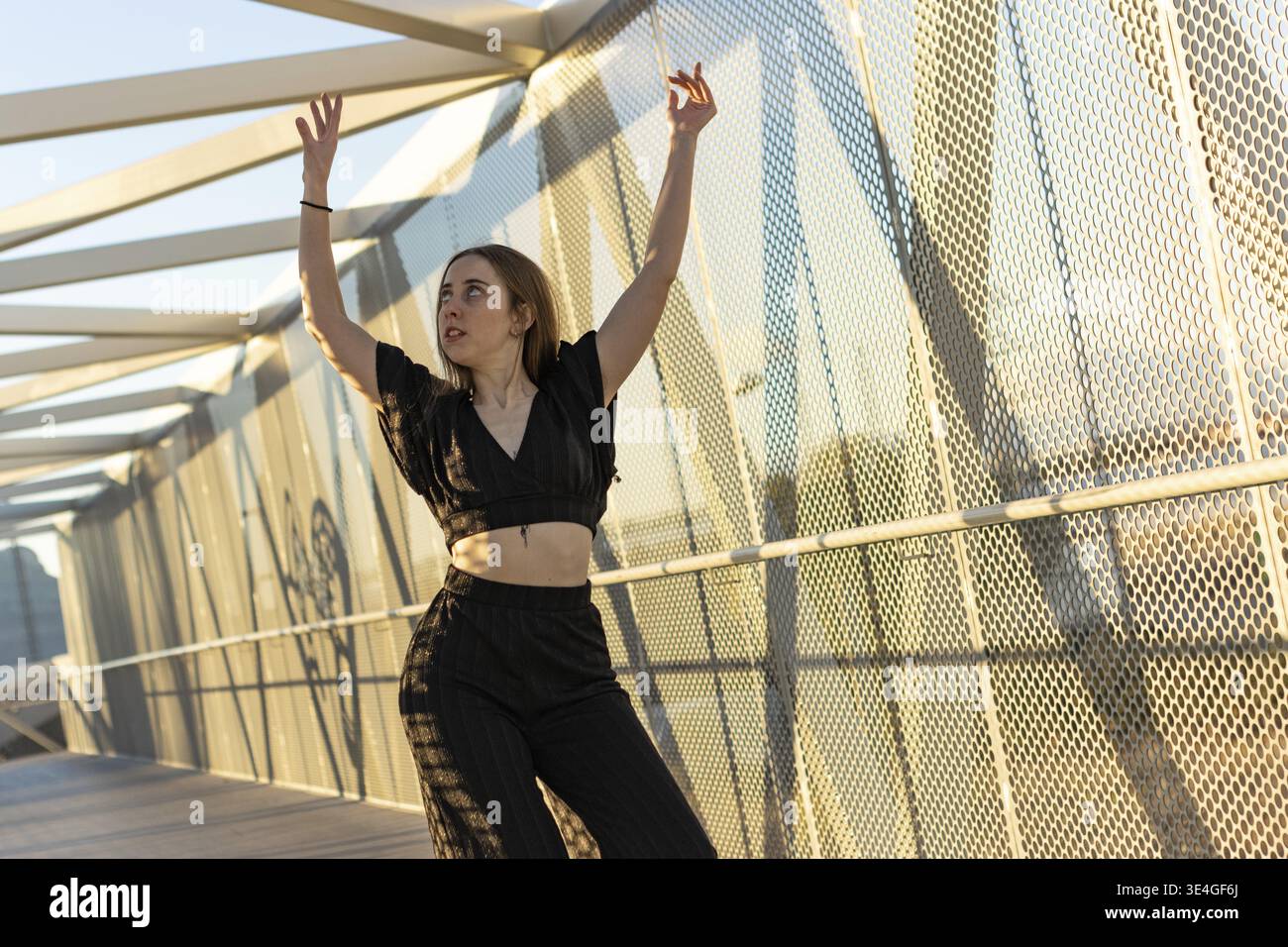 Dancer practicing a modern dance choreography on a pedestrian bridge Stock Photo