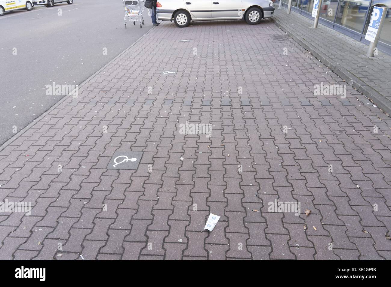 Shopping list is in an empty disabled parking lot next to a parked car in the parking lot of a supermarket in Germany, large empty parking lot with a Stock Photo