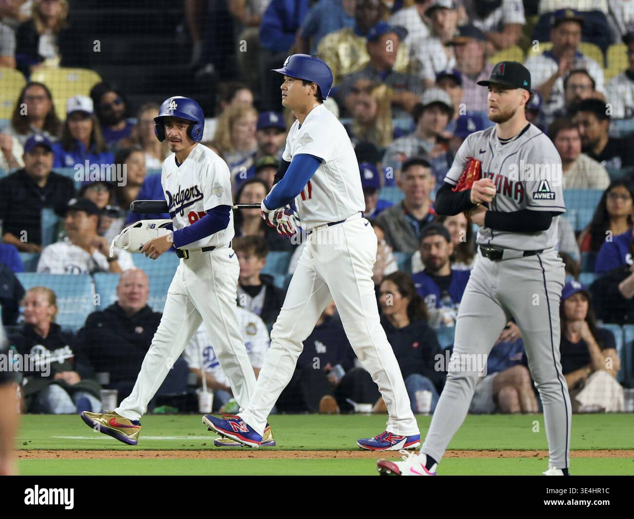 Los Angeles Dodgers Shohei Ohtani, center, walks to first base in the ...