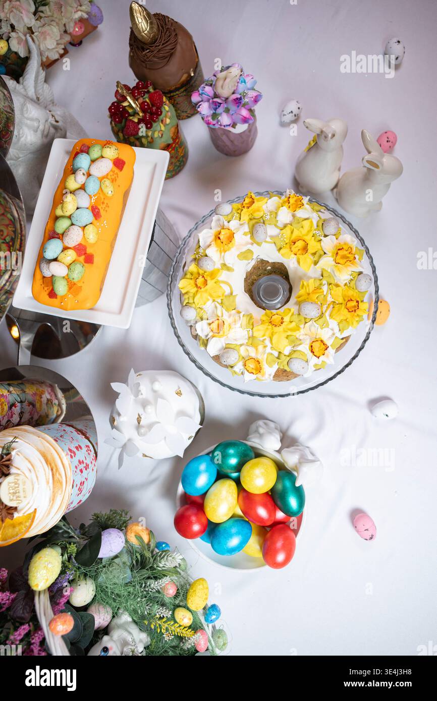 Beautiful overhead view of a festive Easter table covered with colorful desserts. Stock Photo