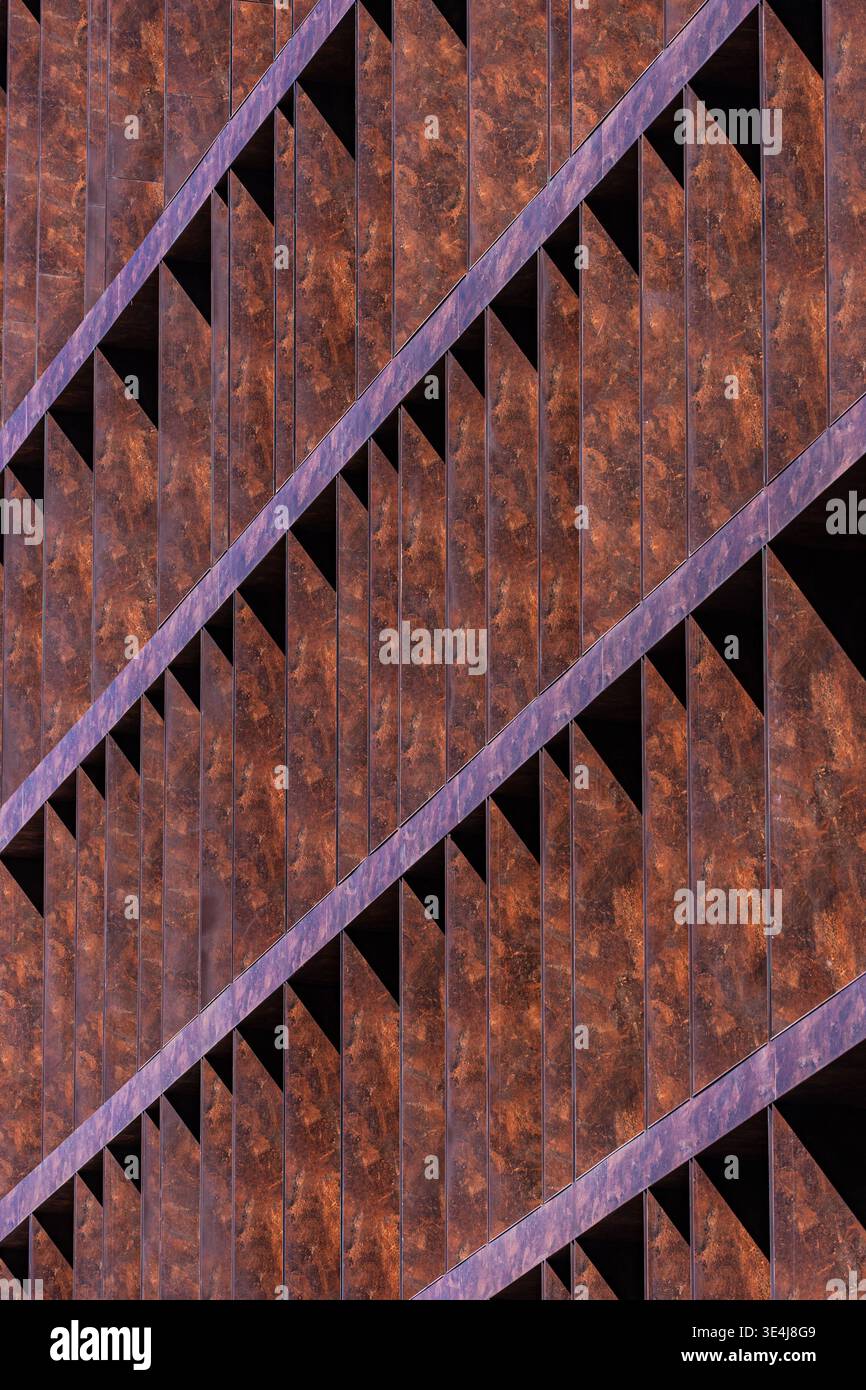 Close-up of modern architecture facade featuring rusted metal panels and sharp diagonal lines. Abstract geometric pattern creates depth, texture, and Stock Photo