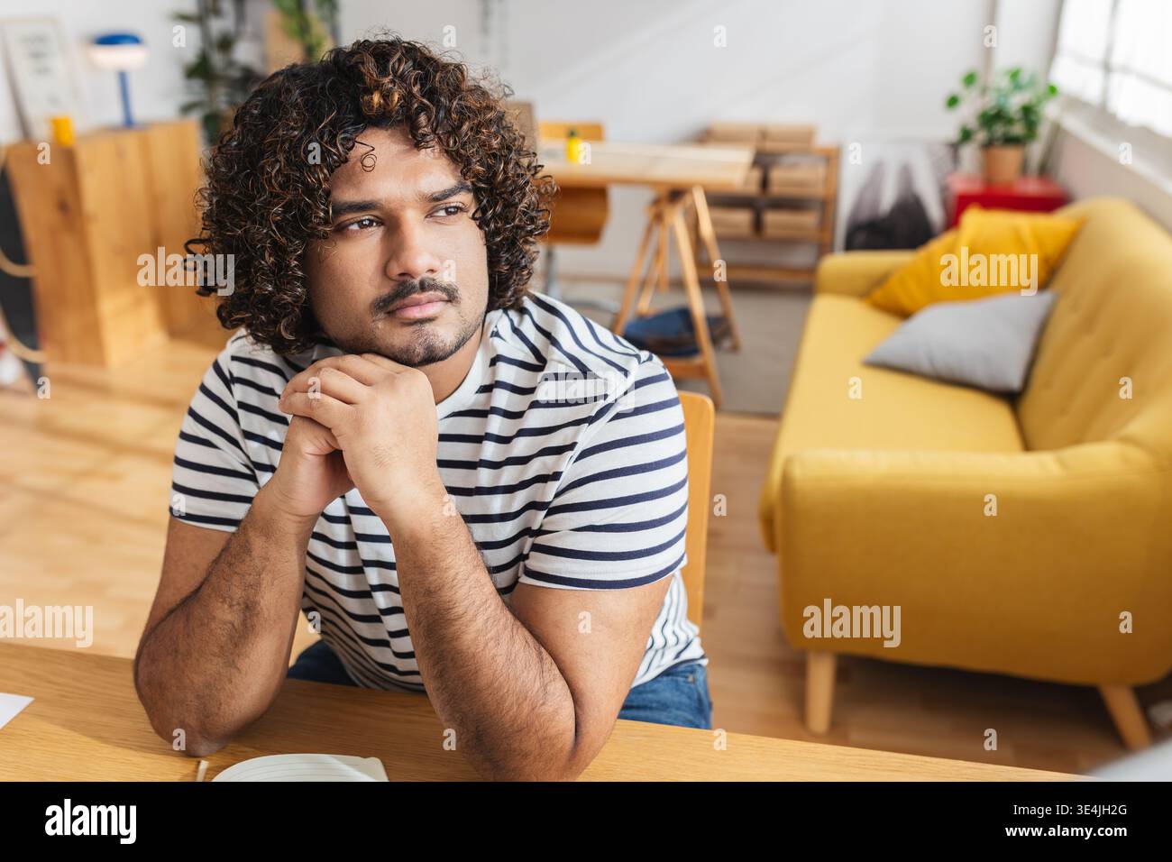 Young Indian man serious while studying at home Stock Photo