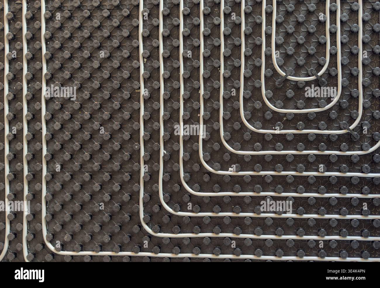 Radiant floor heating layout with pipes installed on thermal insulation Stock Photo