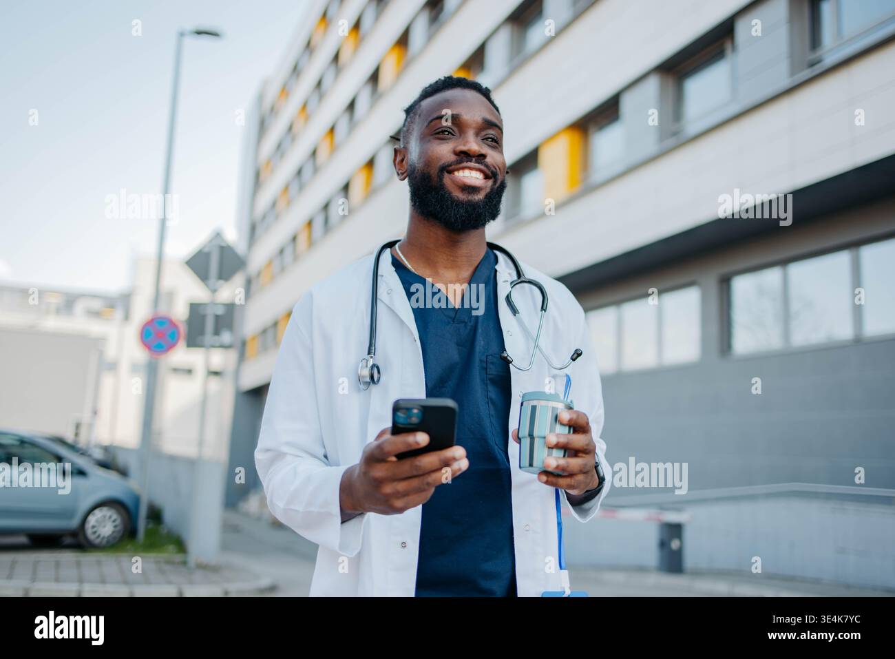 Male Nurse Using Smartphone On Coffee Break Stock Photo