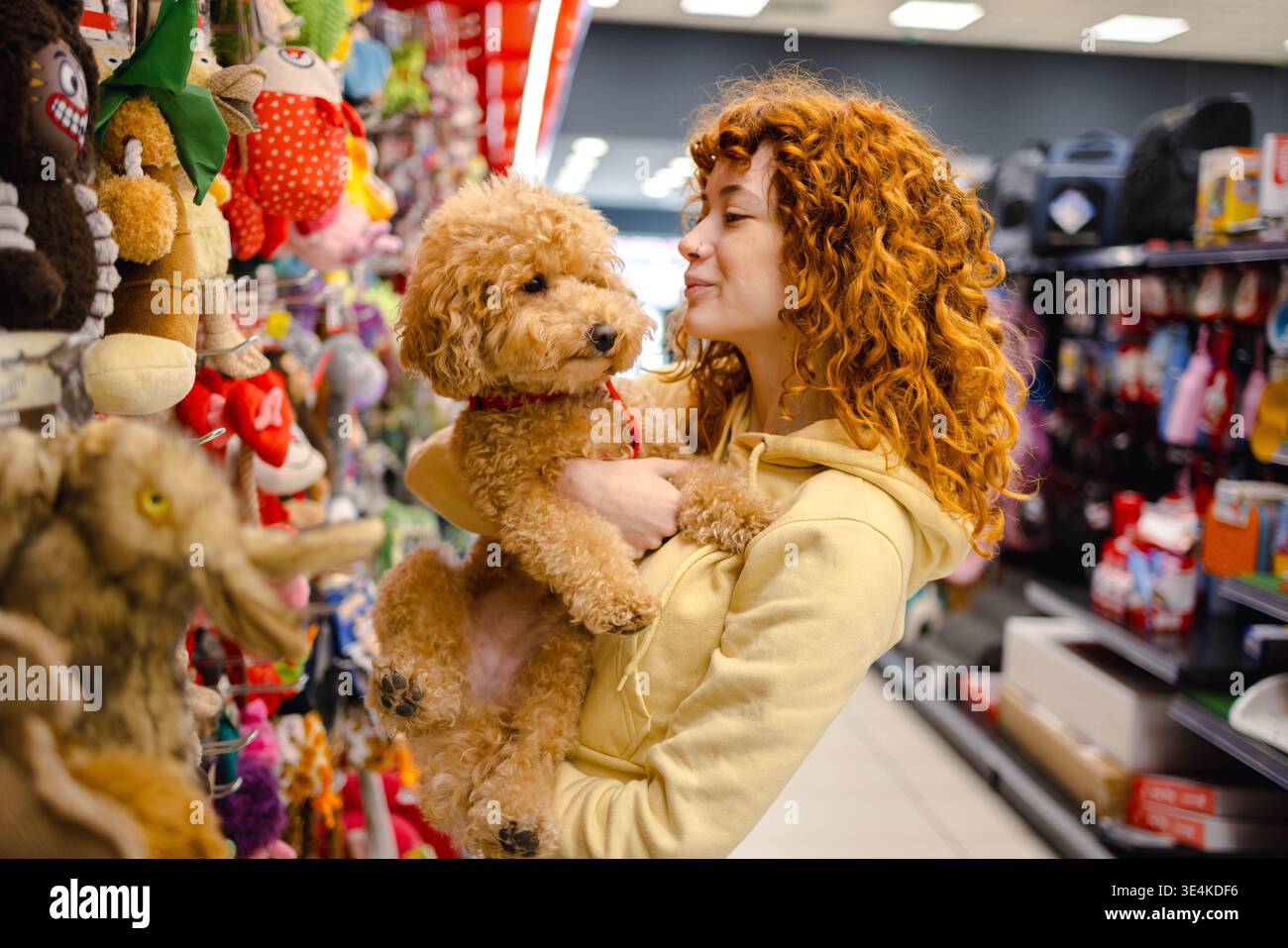 Young woman with poodle in pet shop Stock Photo