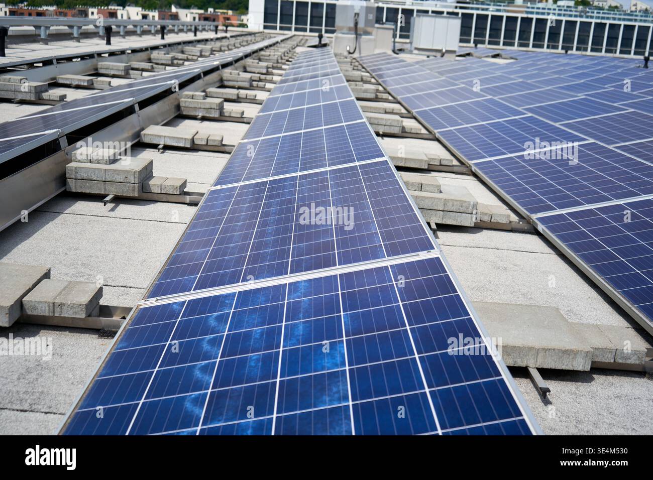 Rows of blue photovoltaic solar panels installed on a flat commercial ...