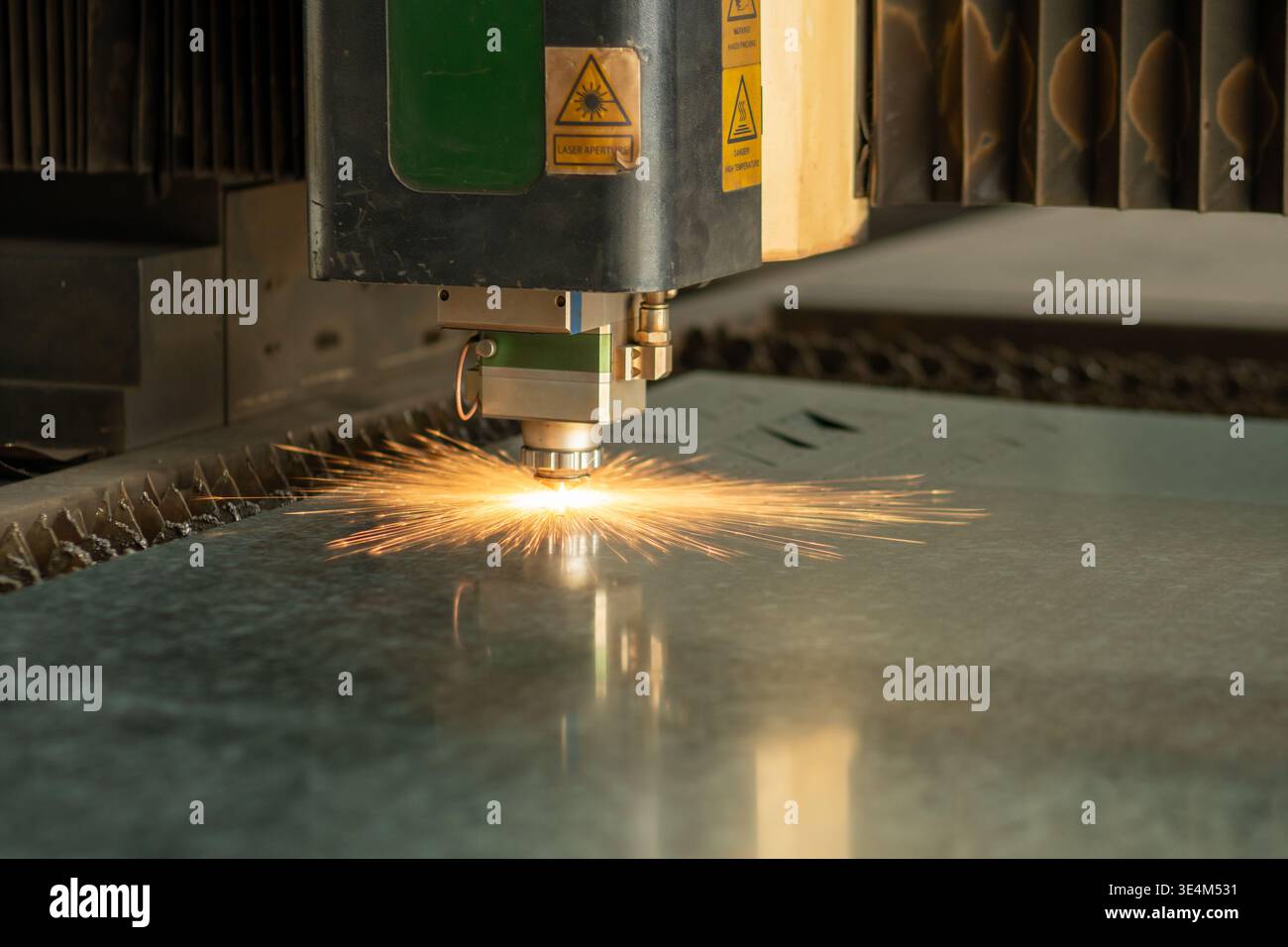 High-Precision Laser Cutting Machine Creating Sparks While Processing Metal Sheet on Industrial Workstation Stock Photo