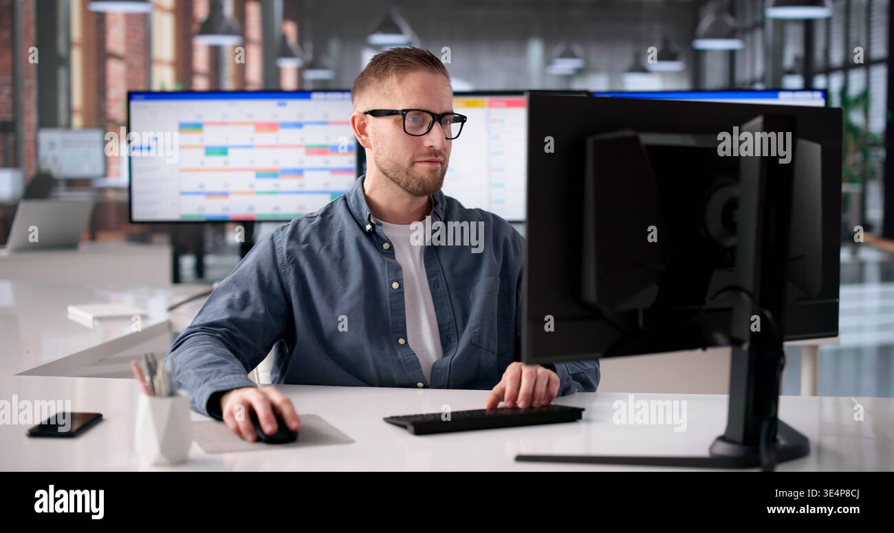 Young Software Developer Strategizes Agile Project Timeline On Computer Using Gantt Chart Stock Photo