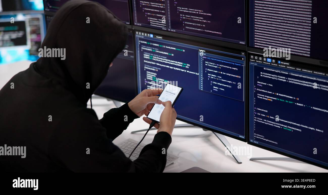 Experienced Hacker Methodically Attempts To Unlock Smartphone PIN In Dark Setting Stock Photo