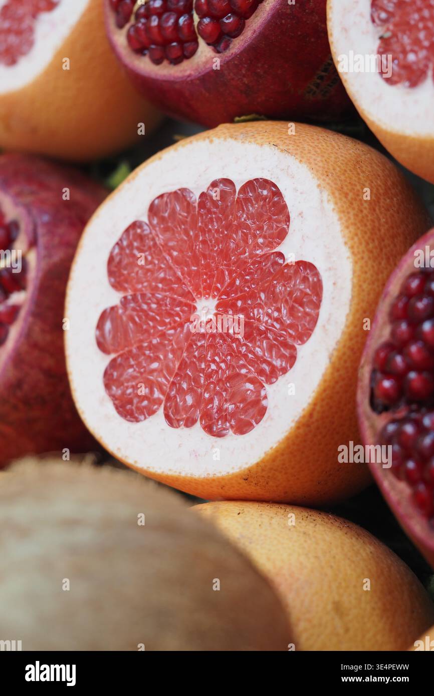 Cut grapefruit with red seeds displayed on a table Stock Photo