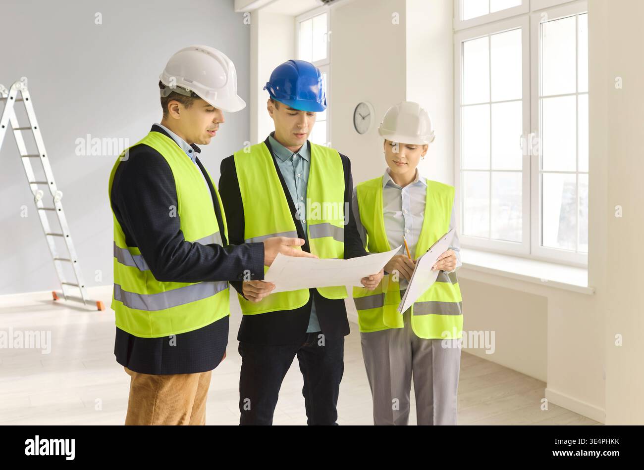 Engineers and contractors review blueprints during interior renovation ...