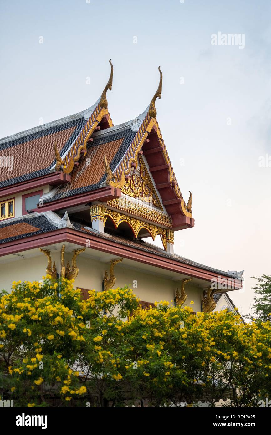 Yellow Temple Traditional Thai temple roof with ornate gables rising above yellow ...