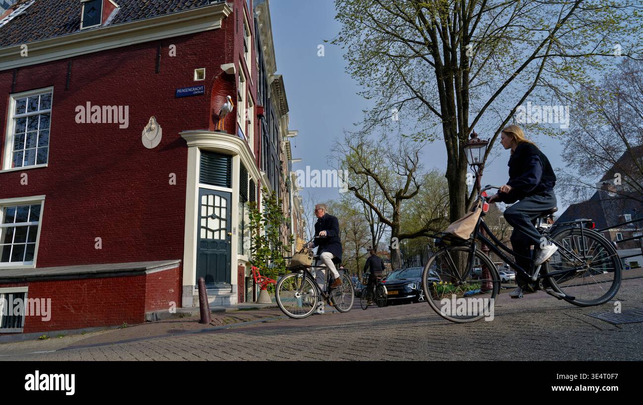 Kunst Malerei ArchitekturTourismus 22.-26.03.2026 Amsterdam Niederlande Holland Prinsengracht Ecke Reguliersgracht Storch Zunftschilder Fahrradfahrer Stock Photo
