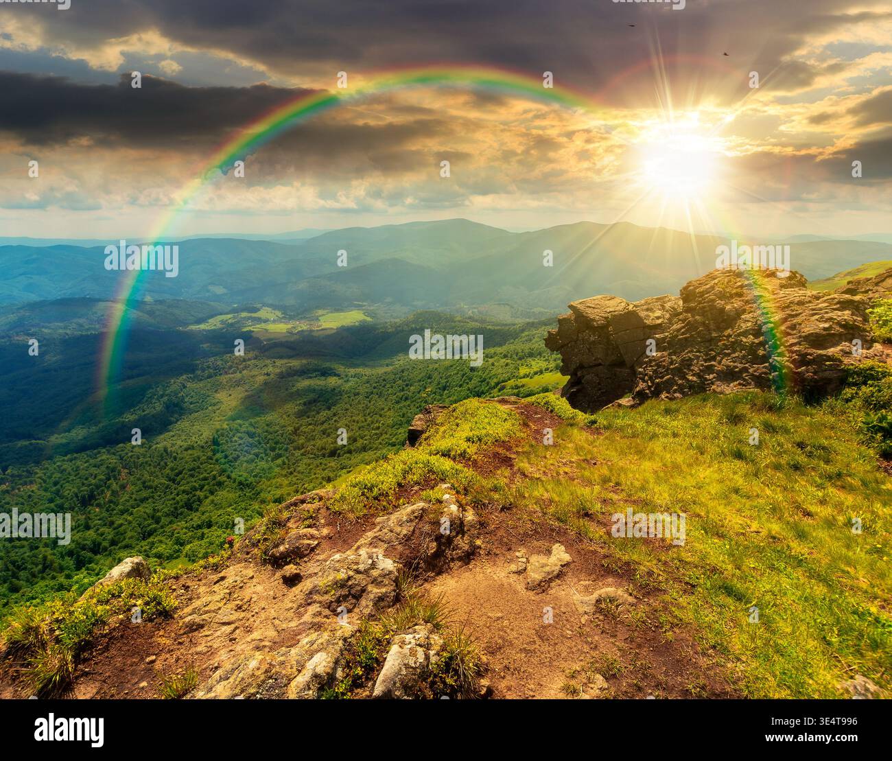 sunset over mountain summer landscape. alpine meadow with huge rocks among the grass on top of the hillside near the peak of mountain range. boulder o Stock Photo