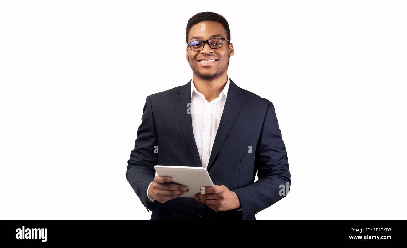 Smiling black guy standing with tablet at studio Stock Photo