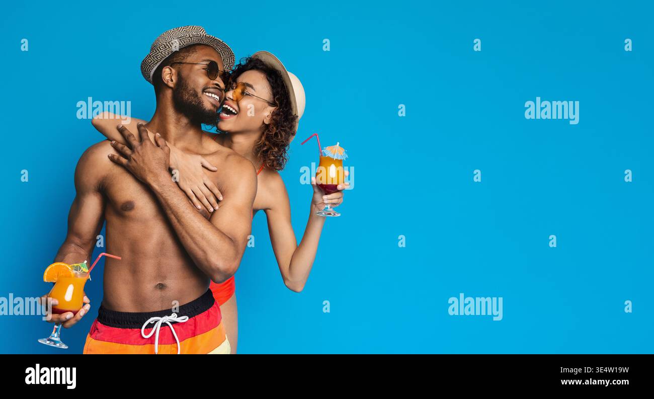 Black couple in love embracing, holding summer cocktails Stock Photo