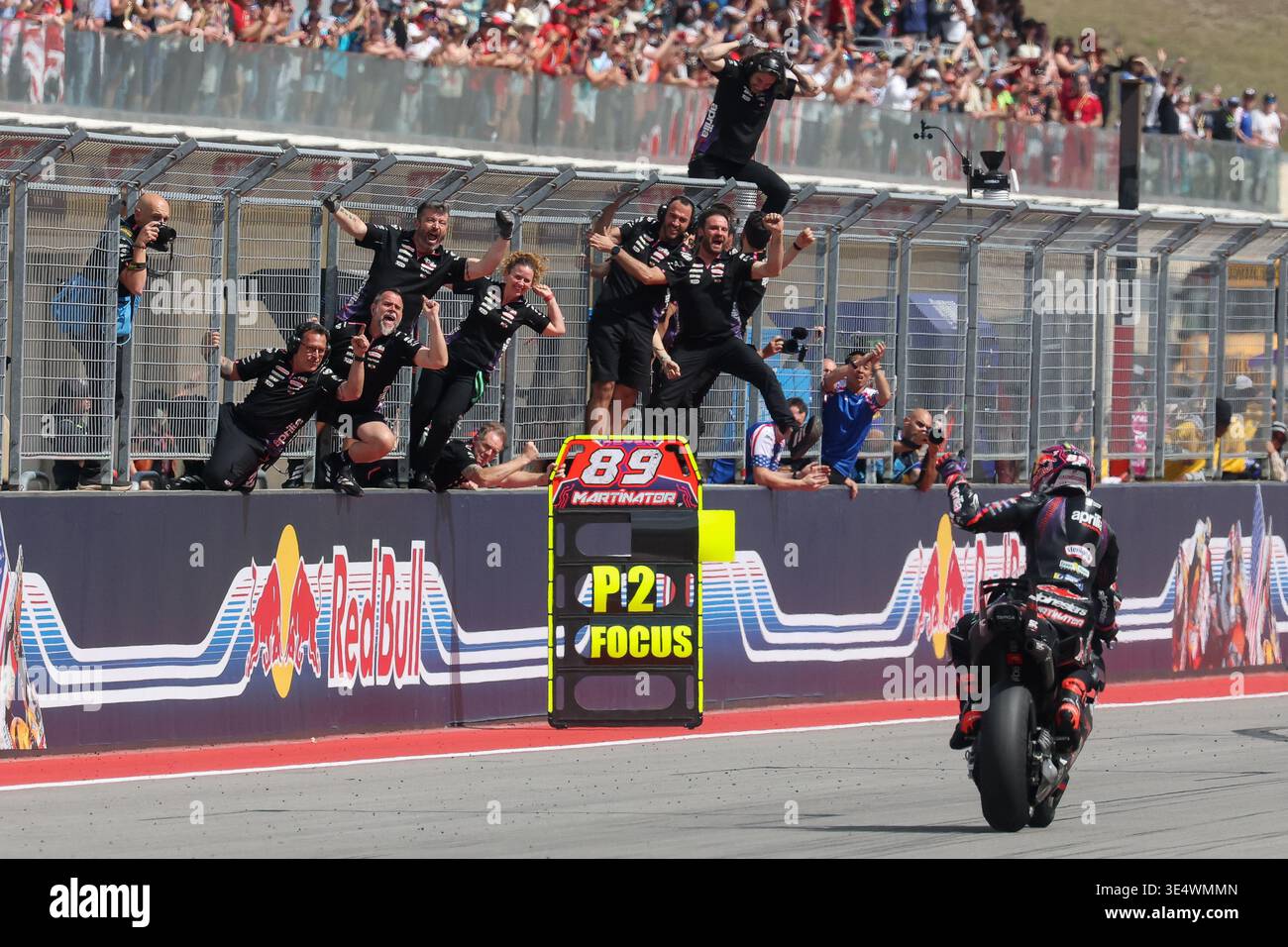 AUSTIN, TX - MARCH 29: Aprilia team members hang off the pit fence as ...