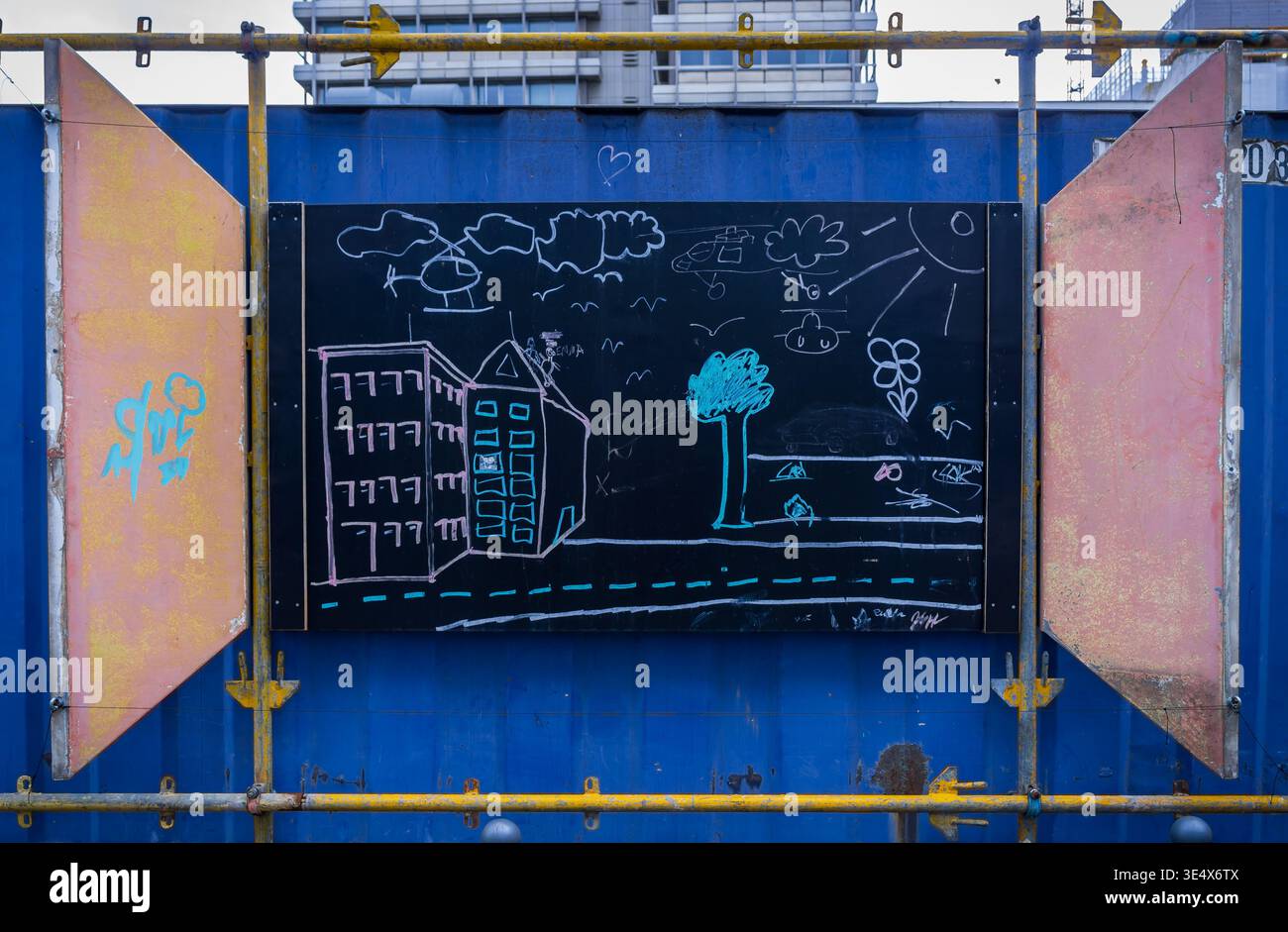 Colorful chalk drawing made by children on a blackboard panel attached to a construction fence in Berlin, Germany. Stock Photo