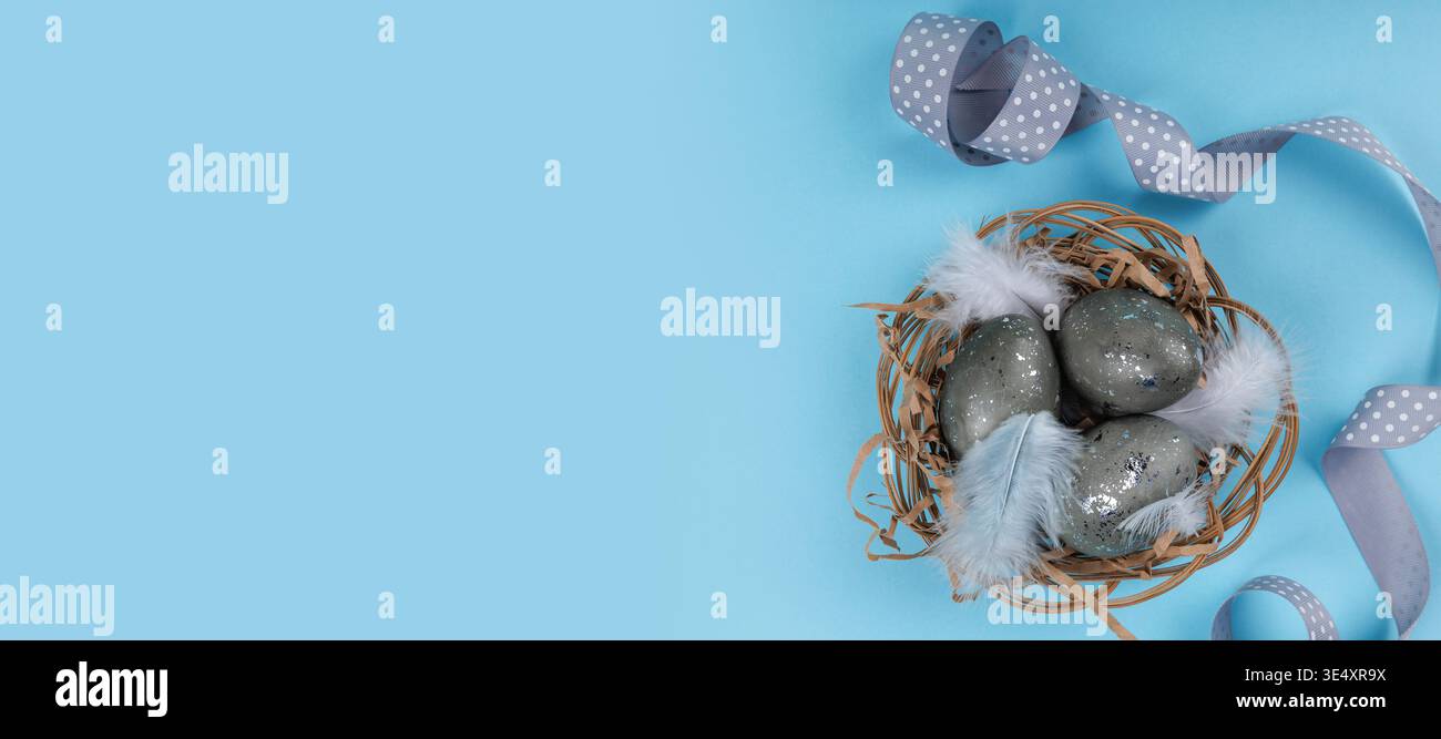Flat lay Easter eggs nest with ribbon and feathers Stock Photo