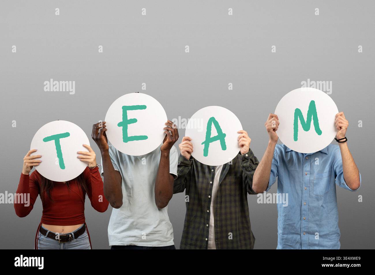 Multicultural group holding round signs forming the word team, concept ...