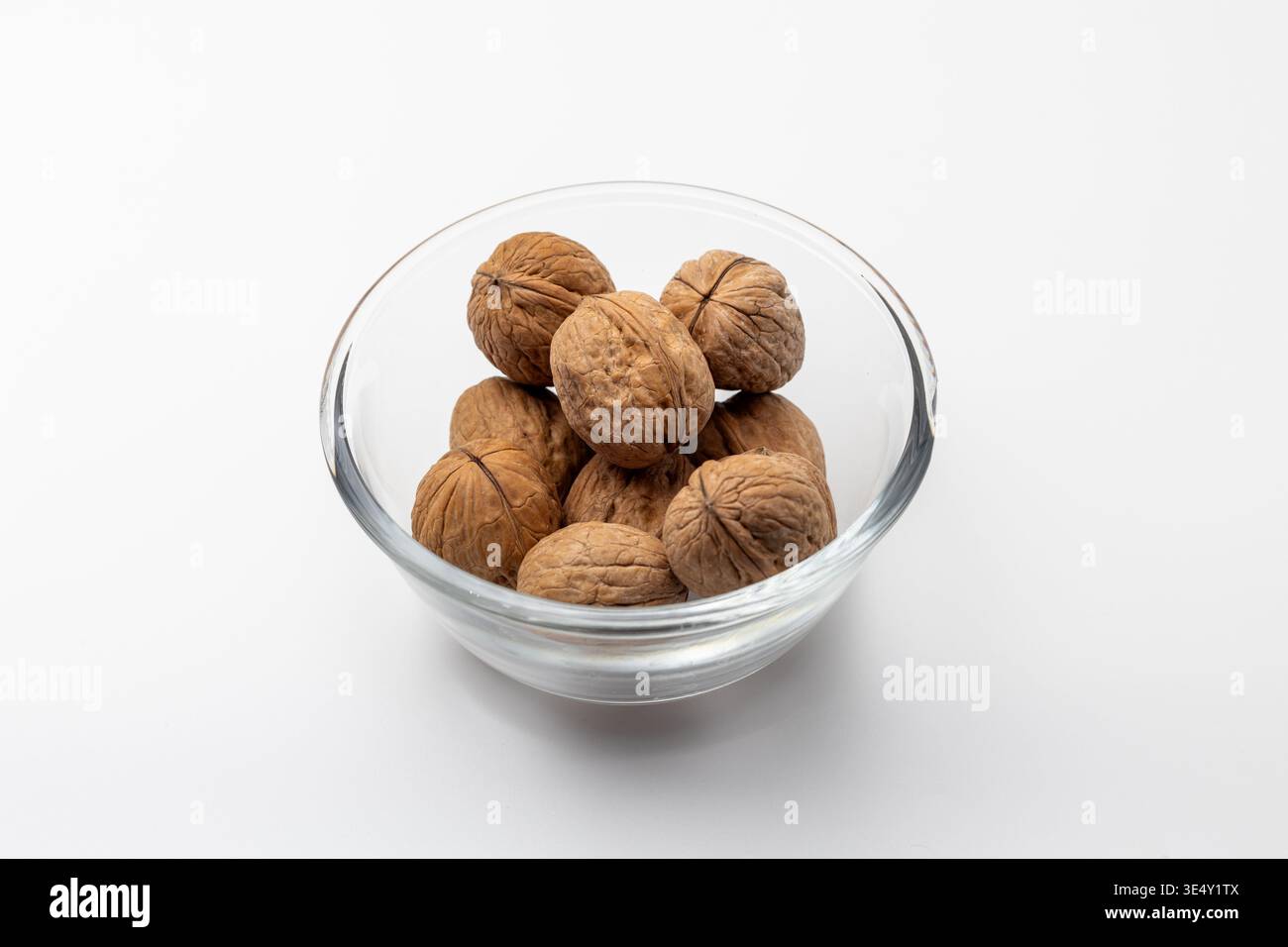 Whole shelled walnuts kept in a glass bowl Stock Photo