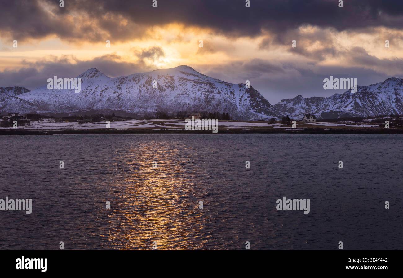 Golden light breaks over the rugged peaks of Leknes, creating a ...