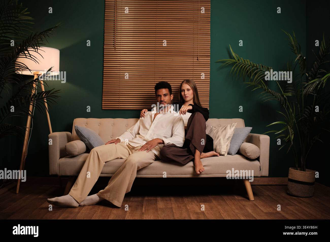 Young diverse couple relaxing together on sofa Stock Photo