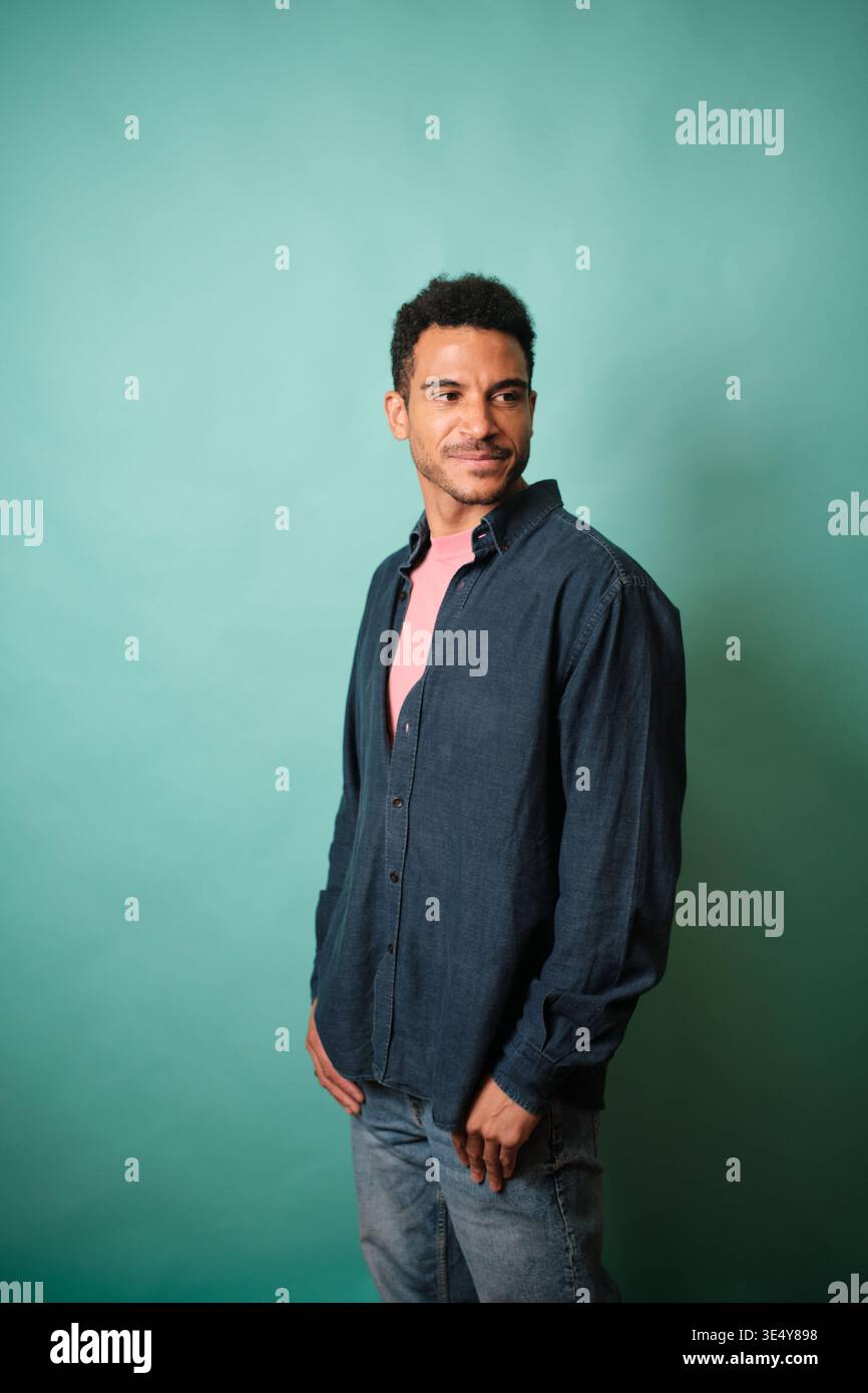 Confident man posing in denim shirt looking away Stock Photo