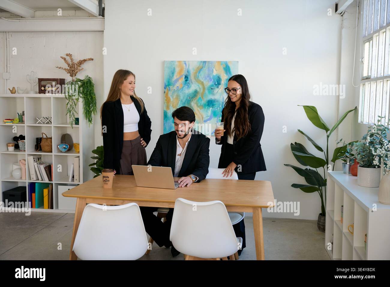 Business team collaborating on laptop in modern office Stock Photo
