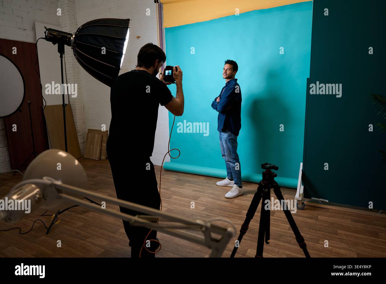 Photographer shooting male model in a studio Stock Photo