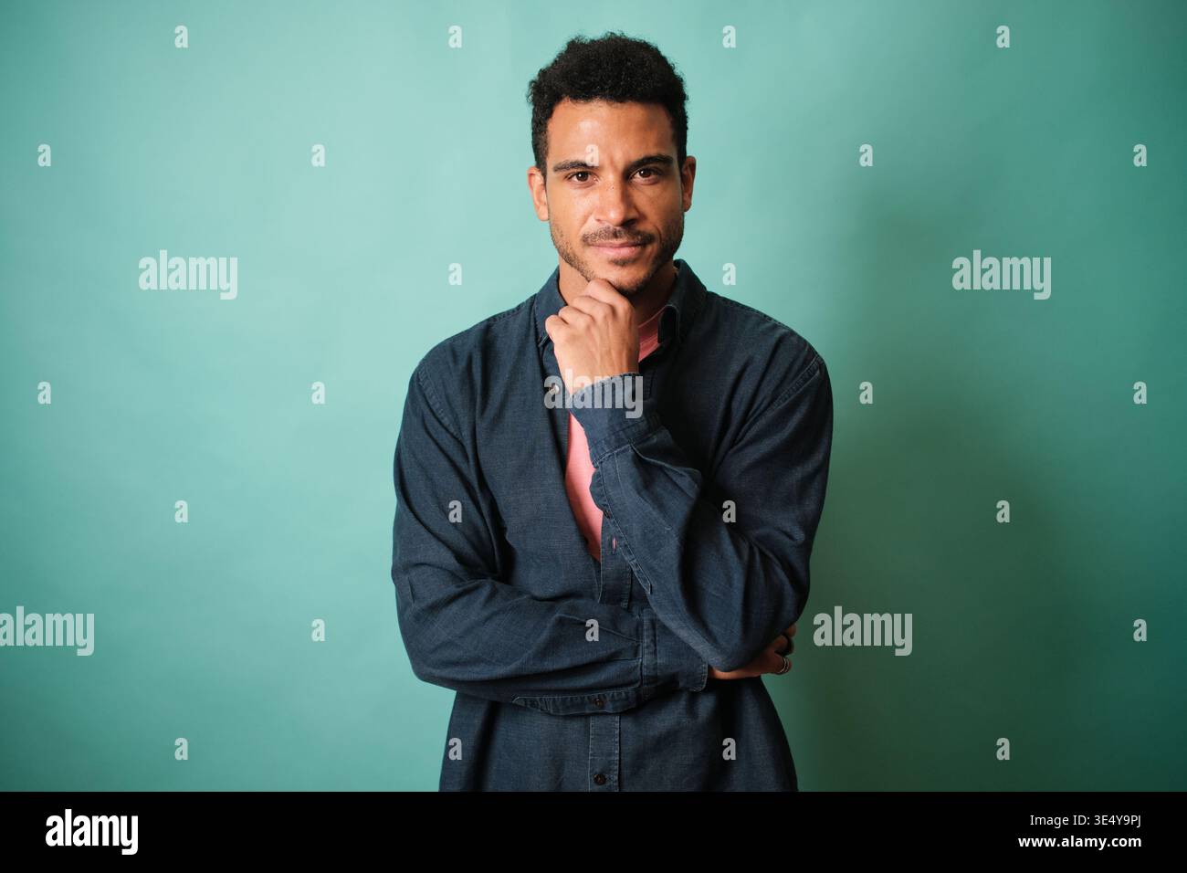 Confident man with thoughtful expression looking at camera Stock Photo