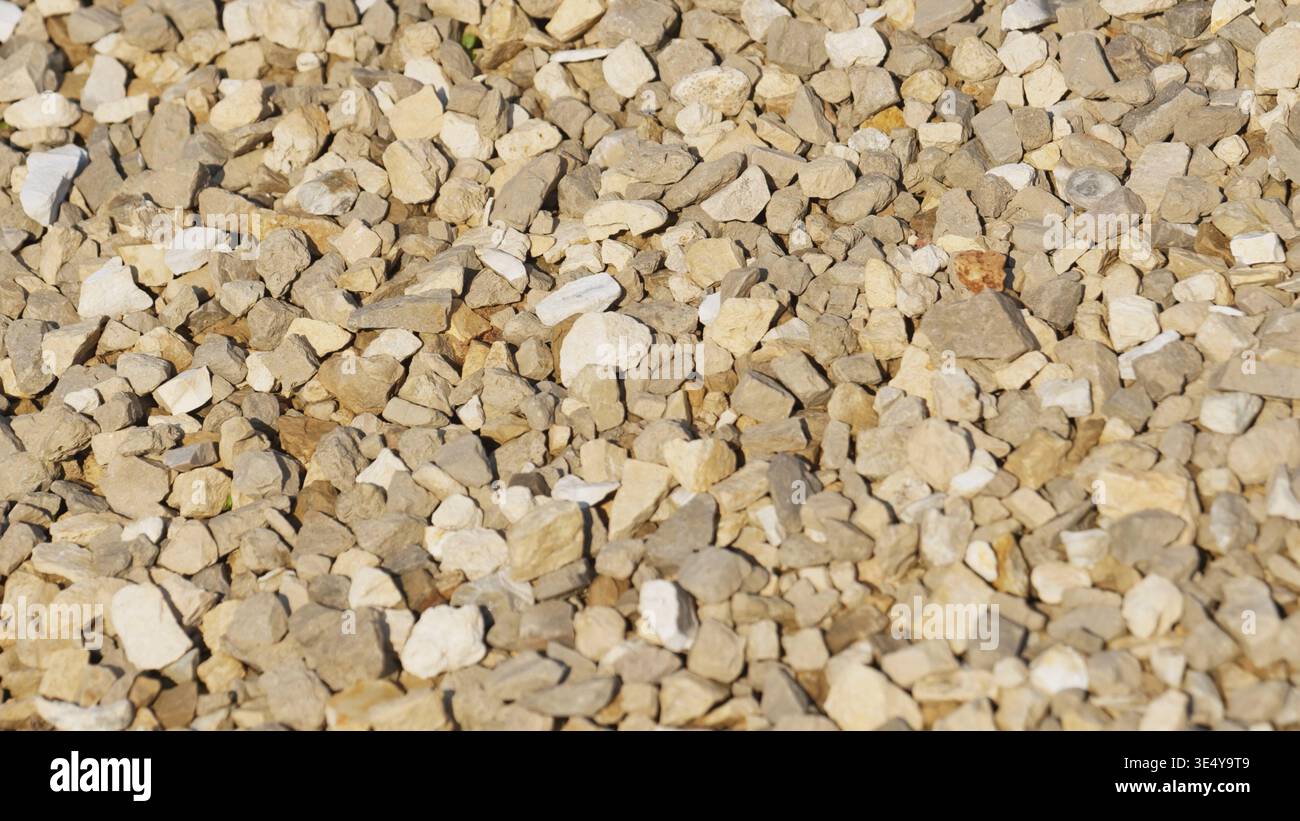 Crushed grey and beige stone creating a uniform rough background texture Stock Photo