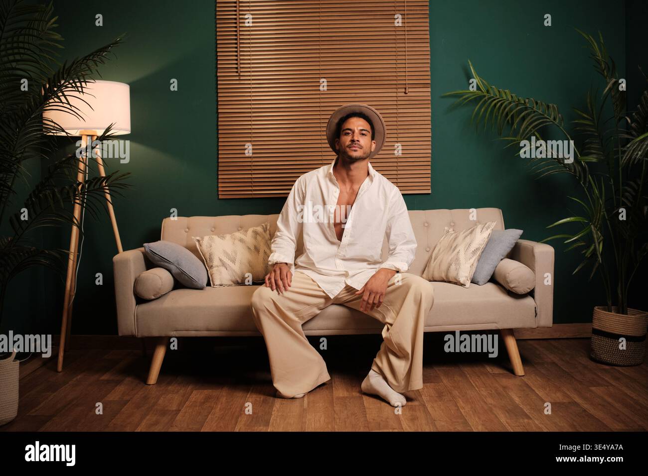 Confident man posing sitting on a stylish couch Stock Photo