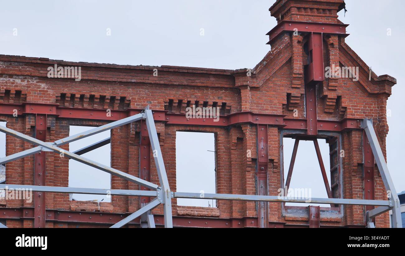 Old brick building facade under renovation with steel reinforcement ...
