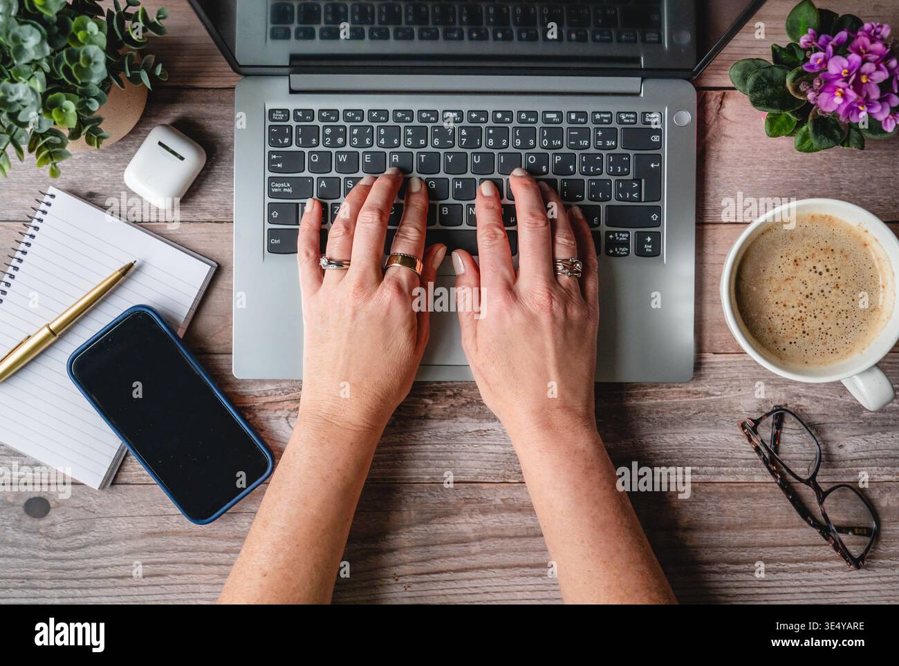 Top view hands typing on computer on desk with phone,coffee. Stock Photo