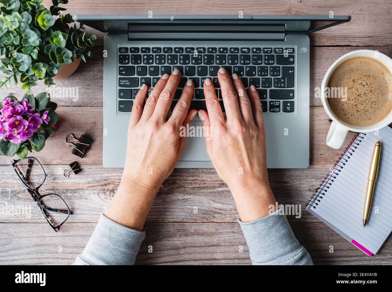 Top view hands typing on laptop computer on desk with coffee. Stock Photo