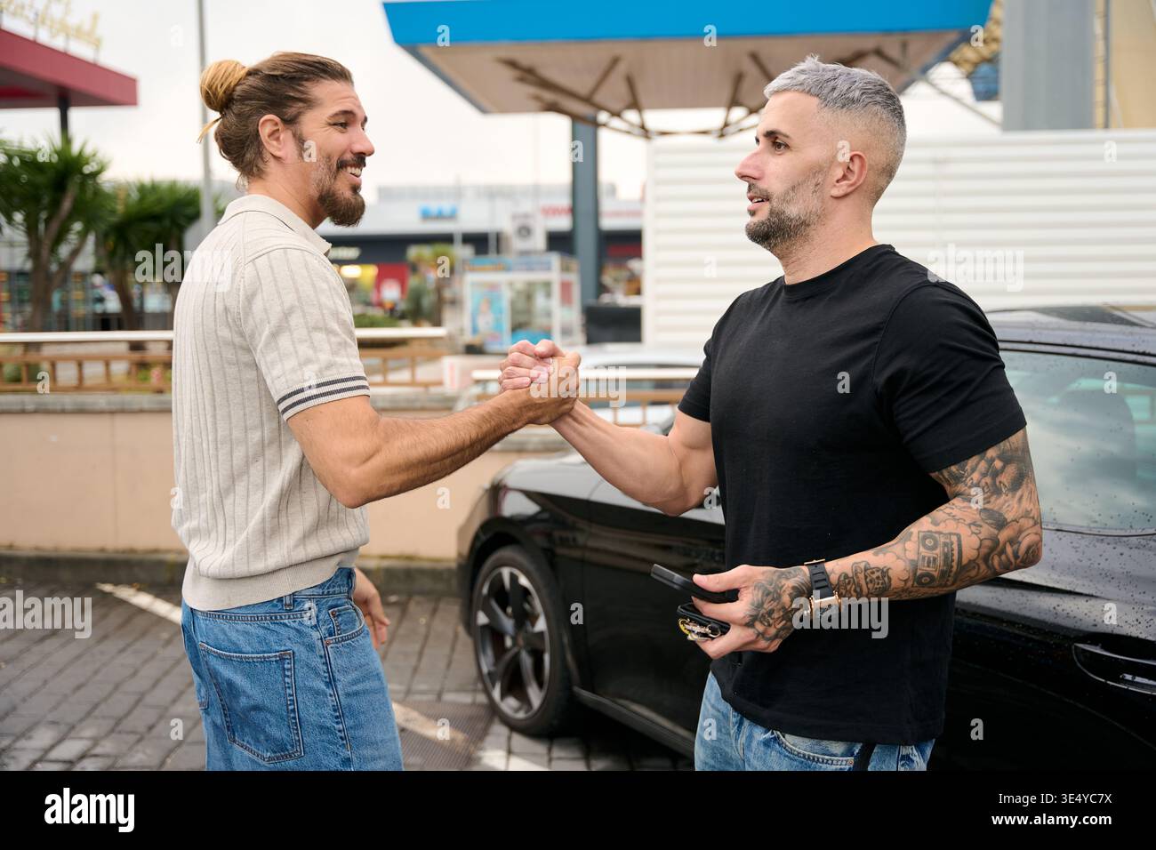 Two young men greeting each other outdoors Stock Photo
