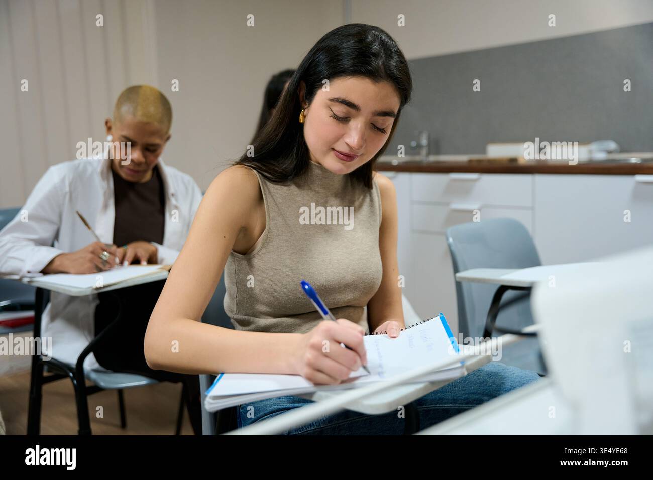 Students learning and writing notes in a classroom Stock Photo