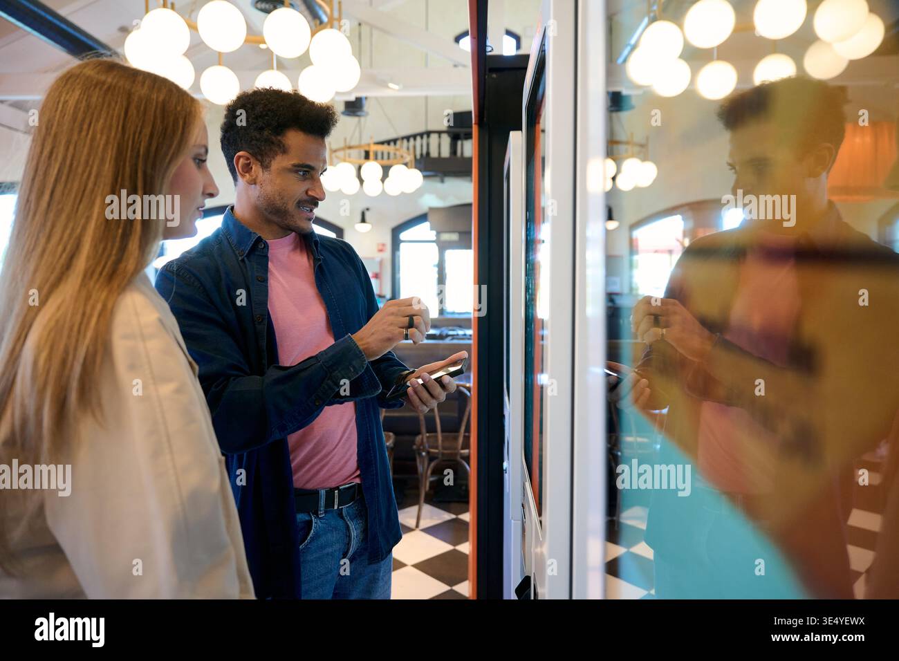 Couple using self service kiosk for ordering food Stock Photo