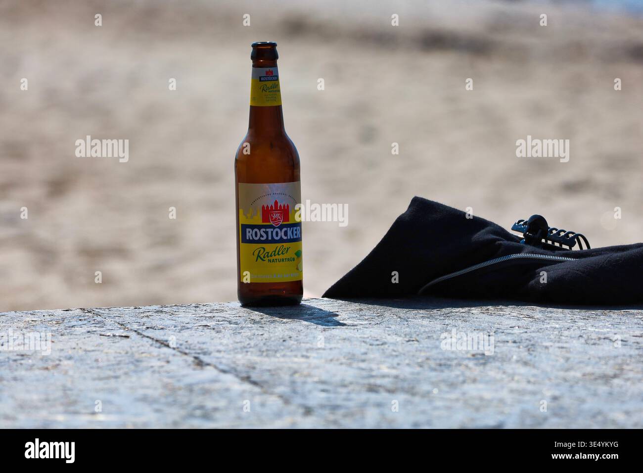 Eine Flasche Rostocker Radler auf einer Mauer am Strand von Rerik an der Ostsee als Symbol für Entspannung und lokalen Genuss im Urlaub Stock Photo