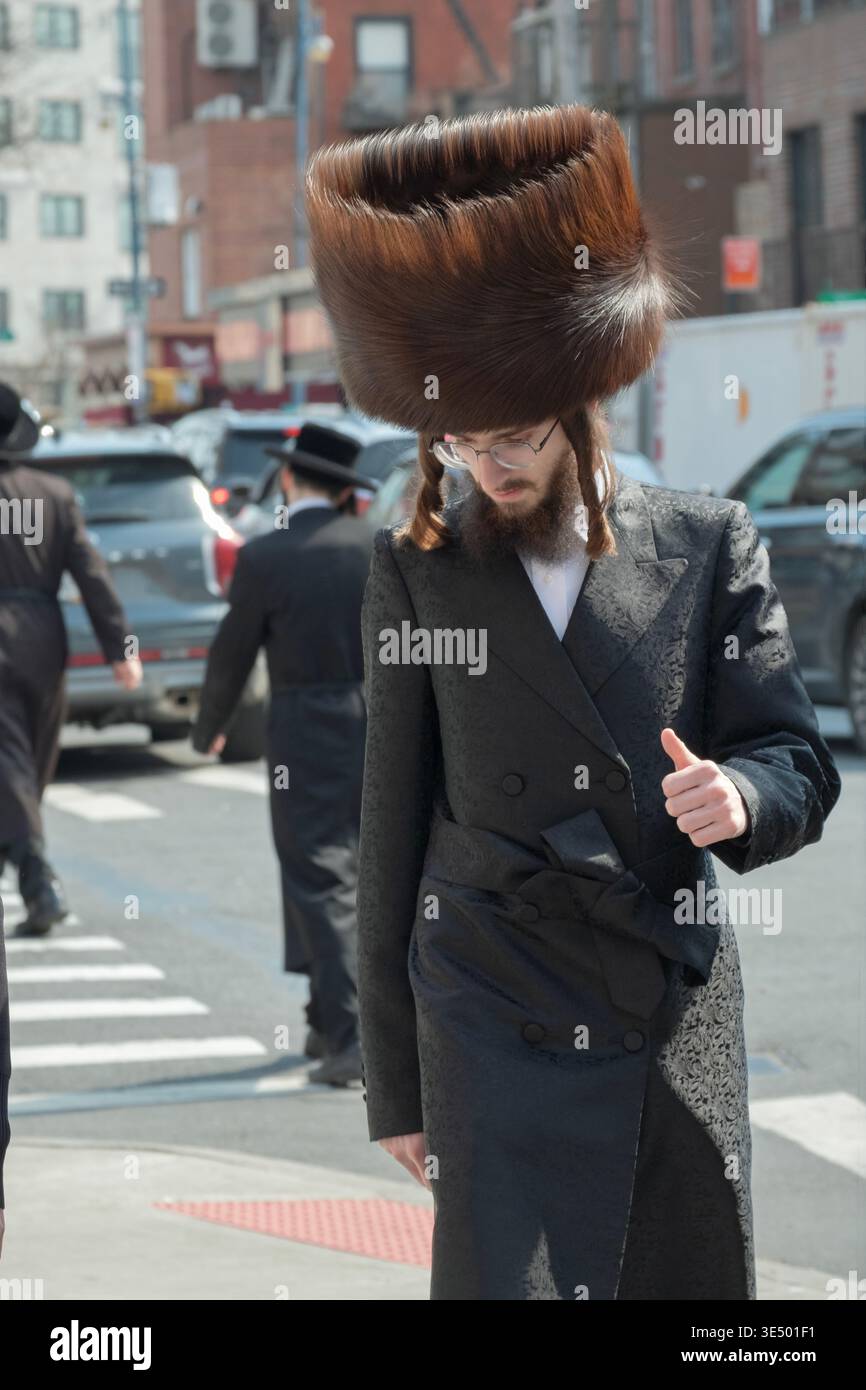 A Jewish man wearing a shtreimel fur hat on a Sunday, likely his wedding day. On on a street in Brooklyn New York Stock Photo