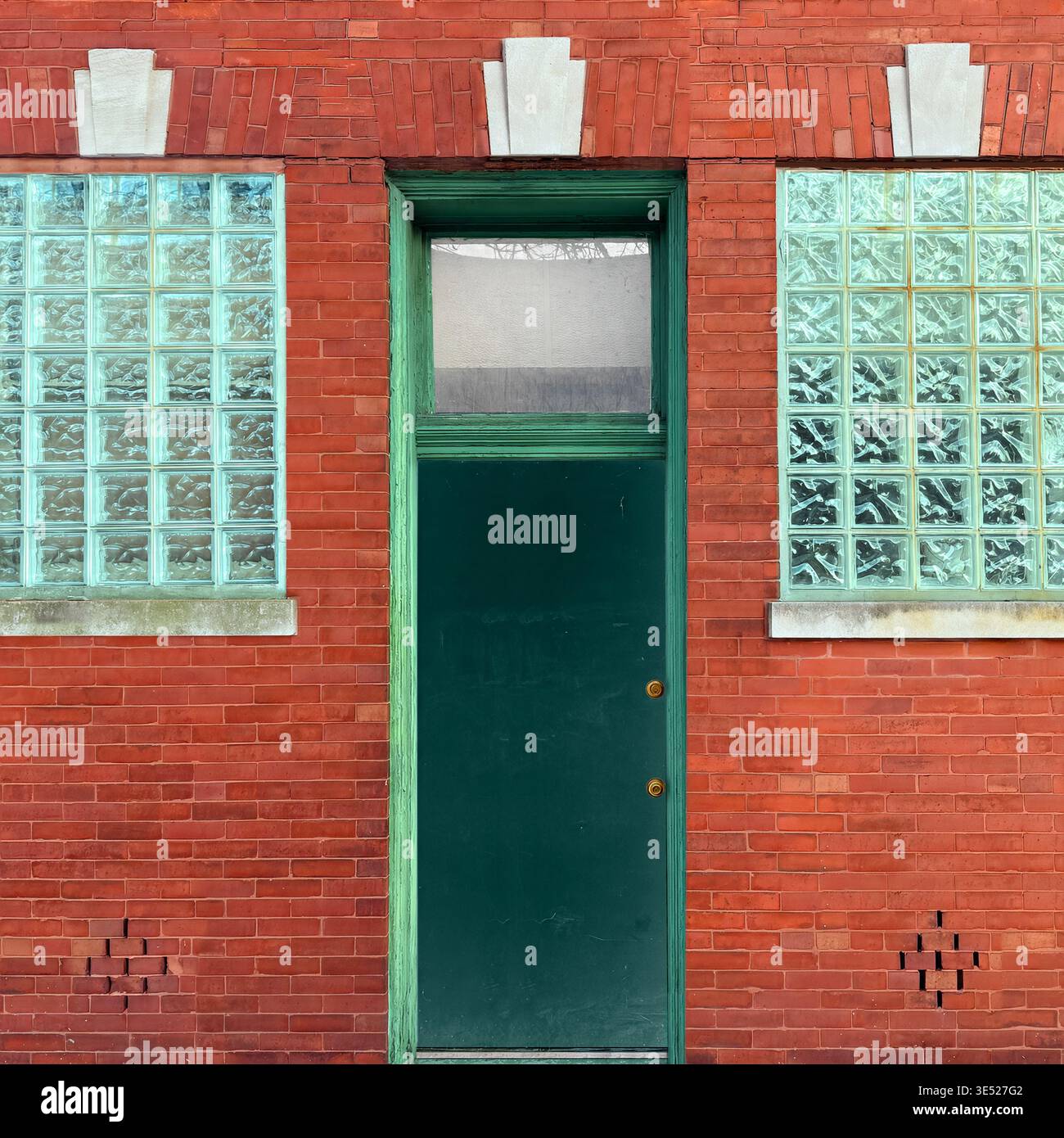 Green door with glass block windows in brick facade, Chicago - Smartphone Captured Stock Image